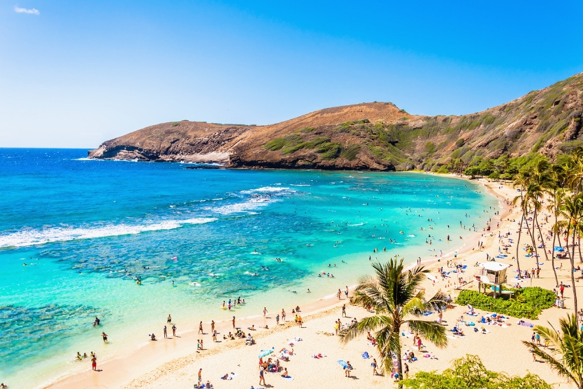 People on a white sand beach at Hanauma Bay in Oahu